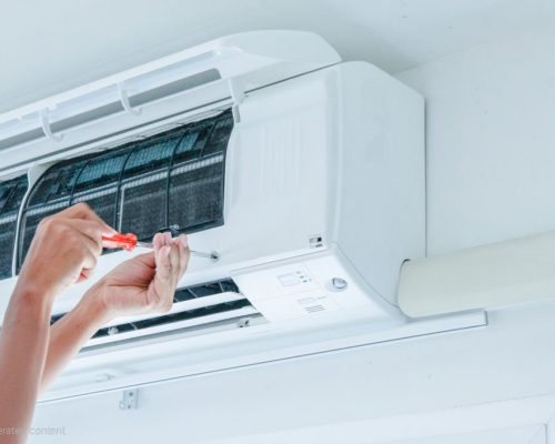 The technician under repairing the air conditioner by use screwdriver The technician under repairing the air conditioner by use screwdriver